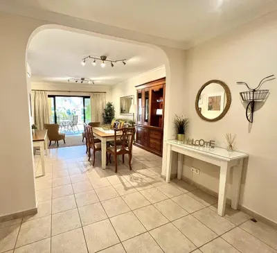 a dining room and living room with a table and a mirror at Olivos del golf - Terrace with pool by HD in Vilamoura