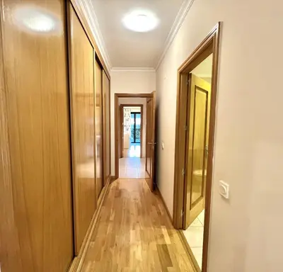 a corridor of an apartment with wooden floors and doors at Olivos del golf - Terrace with pool by HD in Vilamoura