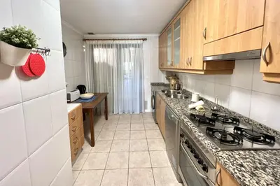 a kitchen with wooden cabinets and a stove top oven at Olivos del golf - Terrace with pool by HD in Vilamoura