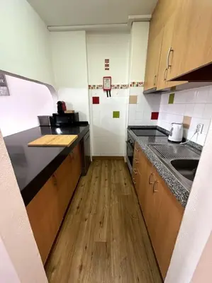 a small kitchen with wooden counters and a wooden floor at Apart 306 in Albufeira