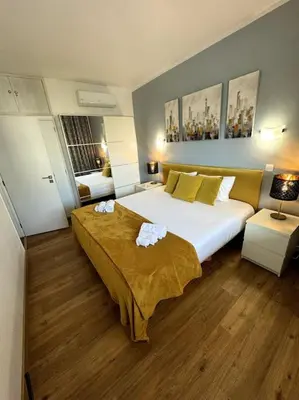 a large bedroom with a large bed with yellow pillows at Apart 306 in Albufeira