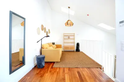 a living room with a yellow couch and a mirror at Zen & Tan Apartment in Faro