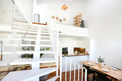 a white staircase in a house with a table at Zen & Tan Apartment in Faro