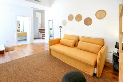 a living room with an orange couch in a room at Zen & Tan Apartment in Faro