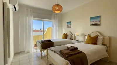 a bedroom with two beds and a large window at Margarida by Check-in Portugal in Albufeira