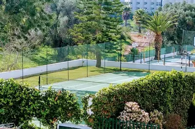 a tennis court with a tennis ball on it at Albufeira SPOT com piscinas exteriores e interior! in Albufeira