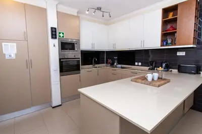 a kitchen with white cabinets and a white counter top at Bay View Modern Apartment in Albufeira