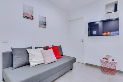 a living room with a couch and a tv at Faro: Casa Trevo com terraço BBQ in Faro