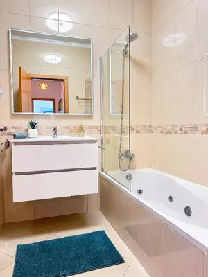 a bathroom with a tub and a sink and a mirror at AlbufeiraOrada II by Be Cherish in Albufeira