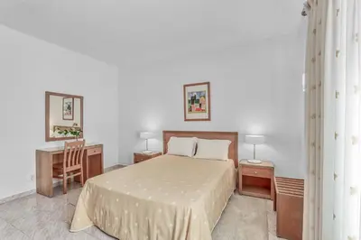 a bedroom with a bed and a desk and a chair at Isabel Vivenda in Patroves