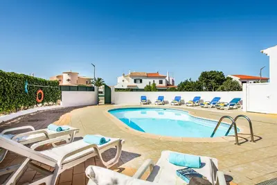 a swimming pool with chaise lounge chairs and a swimming pool at Villa Dois Pinheiros in Albufeira