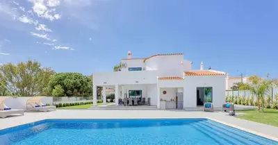 a villa with a swimming pool in front of a house at Villa Sequeira in Albufeira
