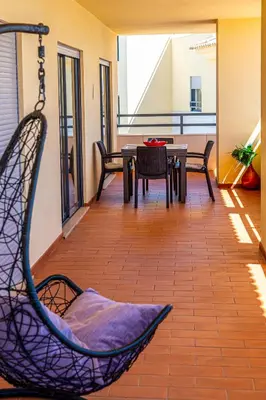a balcony with a table and chairs and a view of the ocean at Corcovada, Sunny and Bright T1 with Large Terrace, Albufeira in Albufeira