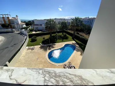 a kitchen with white cabinets and a sink and a dishwasher at Apartamento Mimosas in Albufeira