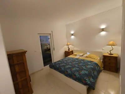 a bedroom with a bed and two lamps and a mirror at Apartamento Mimosas in Albufeira