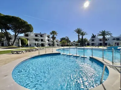 a swimming pool at a resort with palm trees and condos at Albufeira Balaia Golf Vilage 1 With Pool by Homing in Albufeira