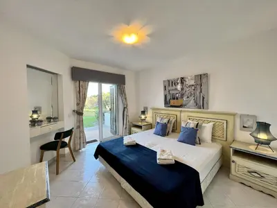 a bedroom with a large bed with a blue blanket at Albufeira Balaia Golf Vilage 1 With Pool by Homing in Albufeira