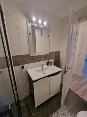 a white bathroom with a sink and a mirror at Apartamento em Quarteira in Quarteira
