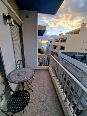 a balcony with a table and chair on a balcony at Apartamento em Quarteira in Quarteira