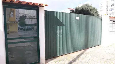 a green fence with a door in front of a building at Visconde By Albufeira Rental in Albufeira