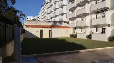 a large apartment building with a lawn in front of it at Visconde By Albufeira Rental in Albufeira