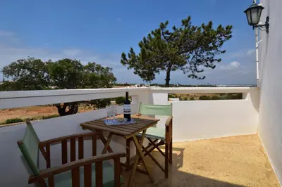 a table and chairs on a balcony with a view of the ocean at Villa Casa Tulipa Sleeps 4 with Pool Garden & A c in Albufeira