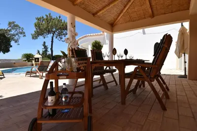 a wooden table and chairs on a patio at Villa Casa Tulipa Sleeps 4 with Pool Garden & A c in Albufeira