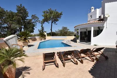 a patio with chairs and a swimming pool at Villa Casa Tulipa Sleeps 4 with Pool Garden & A c in Albufeira