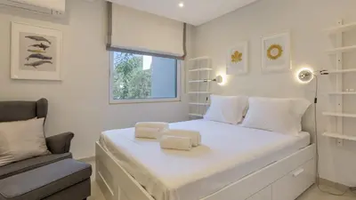 a bedroom with a white bed with two towels on it at Keiko in Vale do Lobo