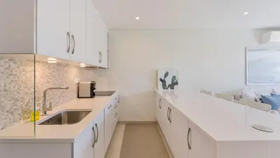 a kitchen with white cabinets and a sink at Keiko in Vale do Lobo