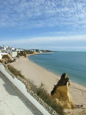 a sandy beach next to a body of water at Private 2 Bed Apartment in Albufeira Old Town in Albufeira