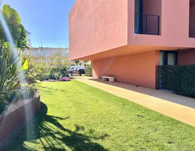 a house with a grassy yard next to a building at One - Luxurious apartment by HD PROPERTIES in Vilamoura