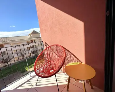 a red chair and a table on a balcony at One - Luxurious apartment by HD PROPERTIES in Vilamoura