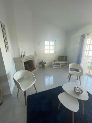 a living room with two chairs and a fireplace at casa Vela in Albufeira