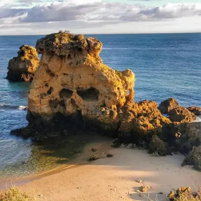 a rock formation on a beach in the ocean at casa Vela in Albufeira