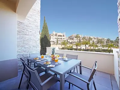 a swimming pool with lounge chairs and a resort at Apartment Pine Hills Esmeralda by Interhome in Vilamoura