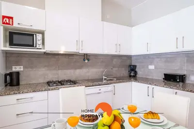 a kitchen with white cabinets and fruit on a table at #099 T1 Caliços by Home Holidays in Albufeira