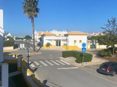 a street with a house and a car on the road at 1-Bed - Sleeps 4 - Free Parking & Balcony in Albufeira
