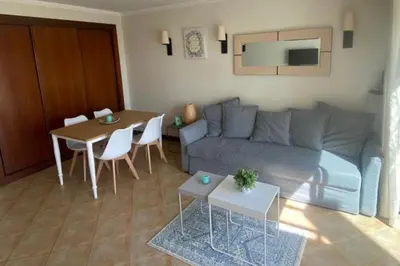 a living room with a couch and a table at 1-Bed - Sleeps 4 - Free Parking & Balcony in Albufeira
