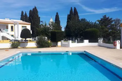 a swimming pool in front of a house at 1-Bed - Sleeps 4 - Free Parking & Balcony in Albufeira