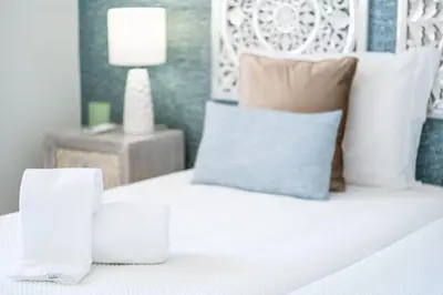 a white bed with two glasses on top of it at Benjamin Apartment in Guia