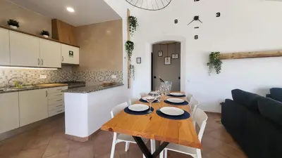 a kitchen and dining room with a wooden table and chairs at Oura Villa V2 Jacarandá in Albufeira