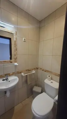 a bathroom with a white toilet and a sink at Oura Villa V2 Jacarandá in Albufeira