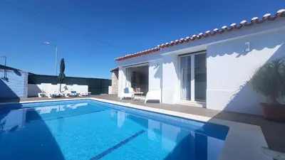 a villa with a swimming pool next to a house at Oura Villa V2 Jacarandá in Albufeira