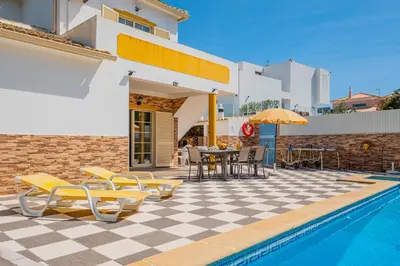 a villa with a pool and a table and chairs at Villa Duarte in Albufeira