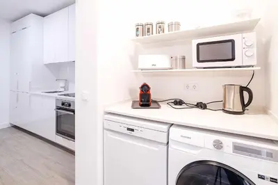 a white kitchen with a washer and dryer at Oura Villa V2 Flores in Albufeira