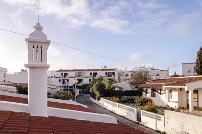 a white lighthouse on the roof of a building at Oura Villa V2 Flores in Albufeira