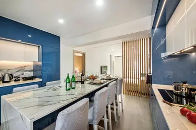 a kitchen with blue walls and a long counter with chairs at Oura Sunset Apartement in Albufeira