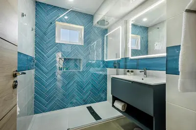 a bathroom with a blue tiled wall at Oura Sunset Apartement in Albufeira