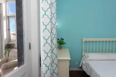 a bedroom with a bed and a blue wall at T3 Apartamento do Tenis in Albufeira